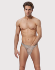 Man wearing the Luné d’Or Lune Lace Thong in gray, front view showing the sheer floral lace front.