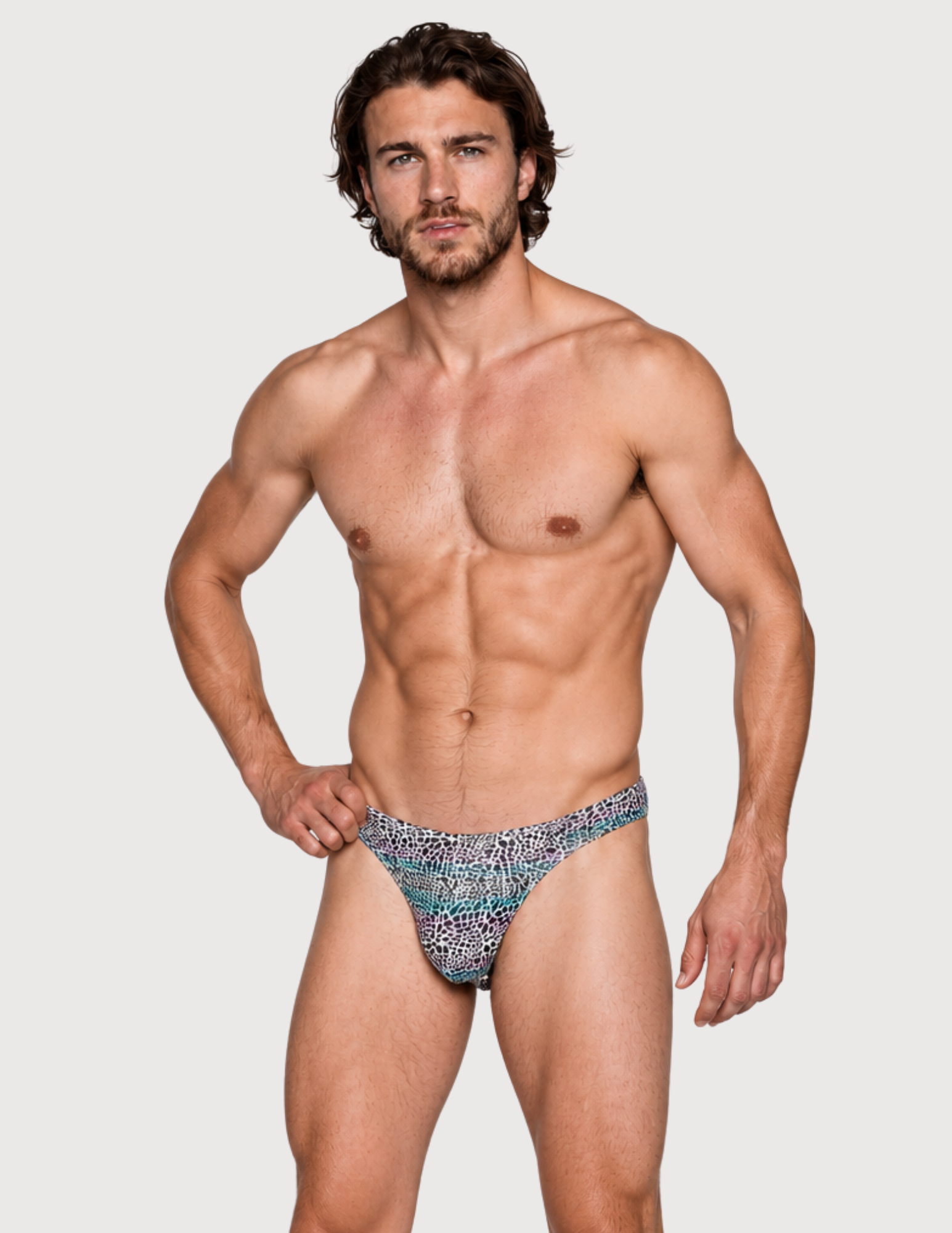 Man wearing the Luné d’Or Mirage Men’s Thong in iridescent leopard, front view showing the printed contour pouch.