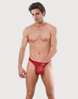 Man wearing the Luné d’Or Lune Lace Thong in red, front view showing the sheer floral lace front.