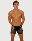 Man wearing the Luné d’Or Men’s Strapped Mesh Jock Brief in black, front view showing architectural straps and sheer mesh thigh bands.