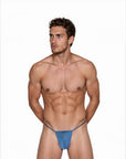 Man wearing the Luné d’Or Fil Men’s G-String in blue, front view showing the minimal contour pouch and thin waistband.