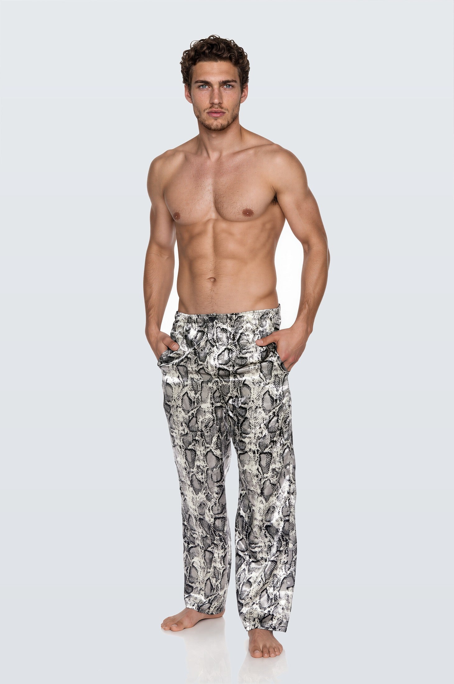Man wearing the Luné d’Or Men’s Satin Lounge Pant in snake print, front view showing the elastic waistband and wide straight leg.