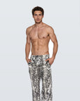 Man wearing the Luné d’Or Men’s Satin Lounge Pant in snake print, front view showing the elastic waistband and wide straight leg.