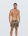 Man wearing the Luné d’Or Men’s Satin Lounge Short in leopard print, front view showing the elastic waistband and relaxed leg.